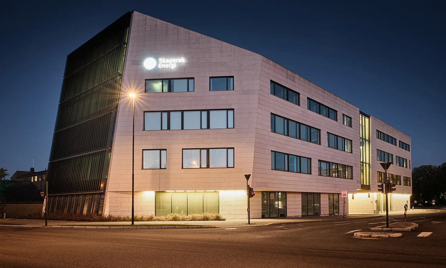 Hovedbygget til Skagerak Energi sett i kveldslys, med logo og skarpt linjespill i fasaden.