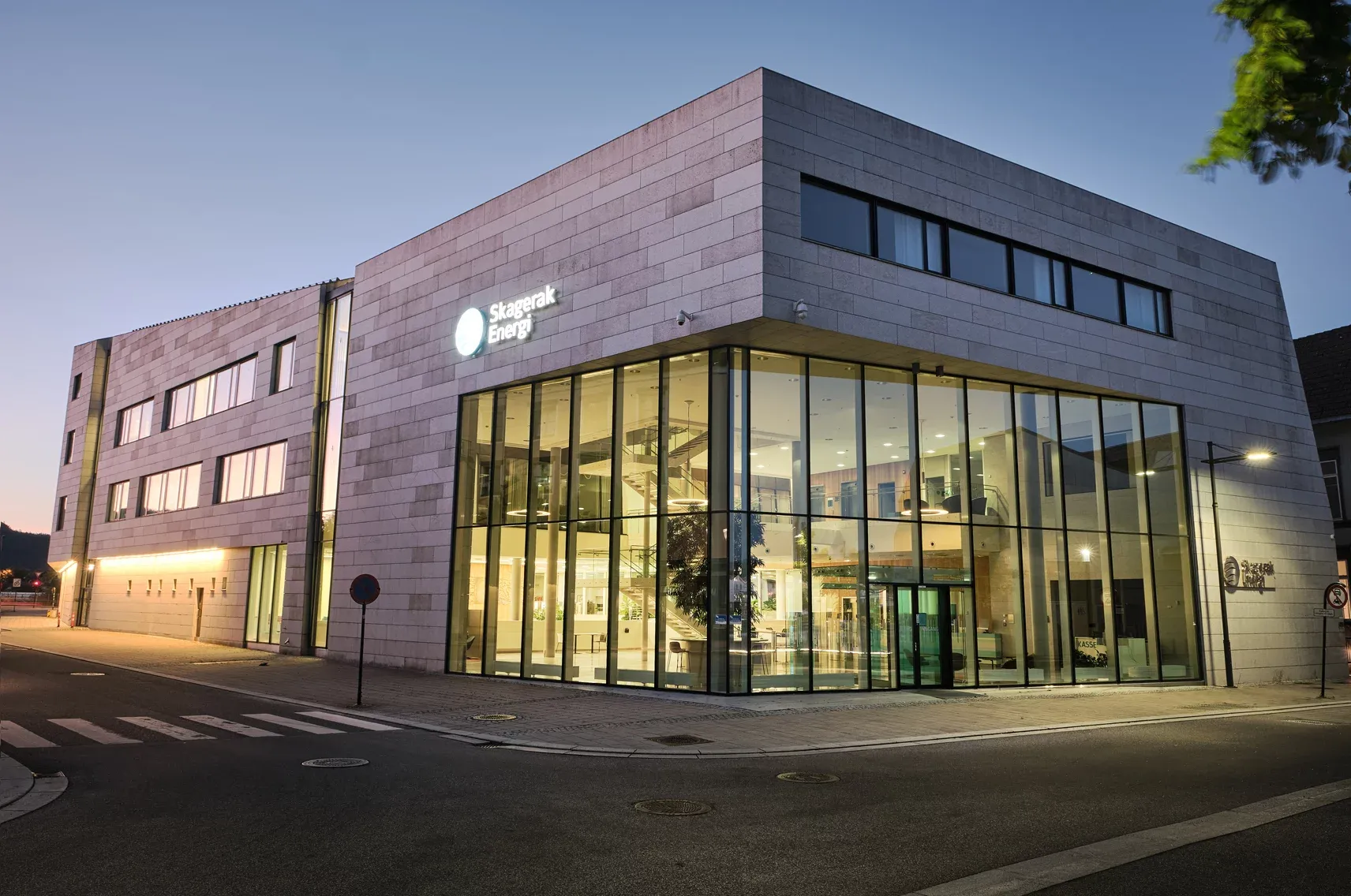 Hjørneperspektiv av Skagerak Energi med stor glassfasade og innsyn til åpen resepsjon og atrium.