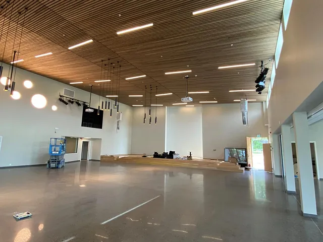 Kirkerom sett fra baksiden av salen, med høyt tak og moderne belysning.