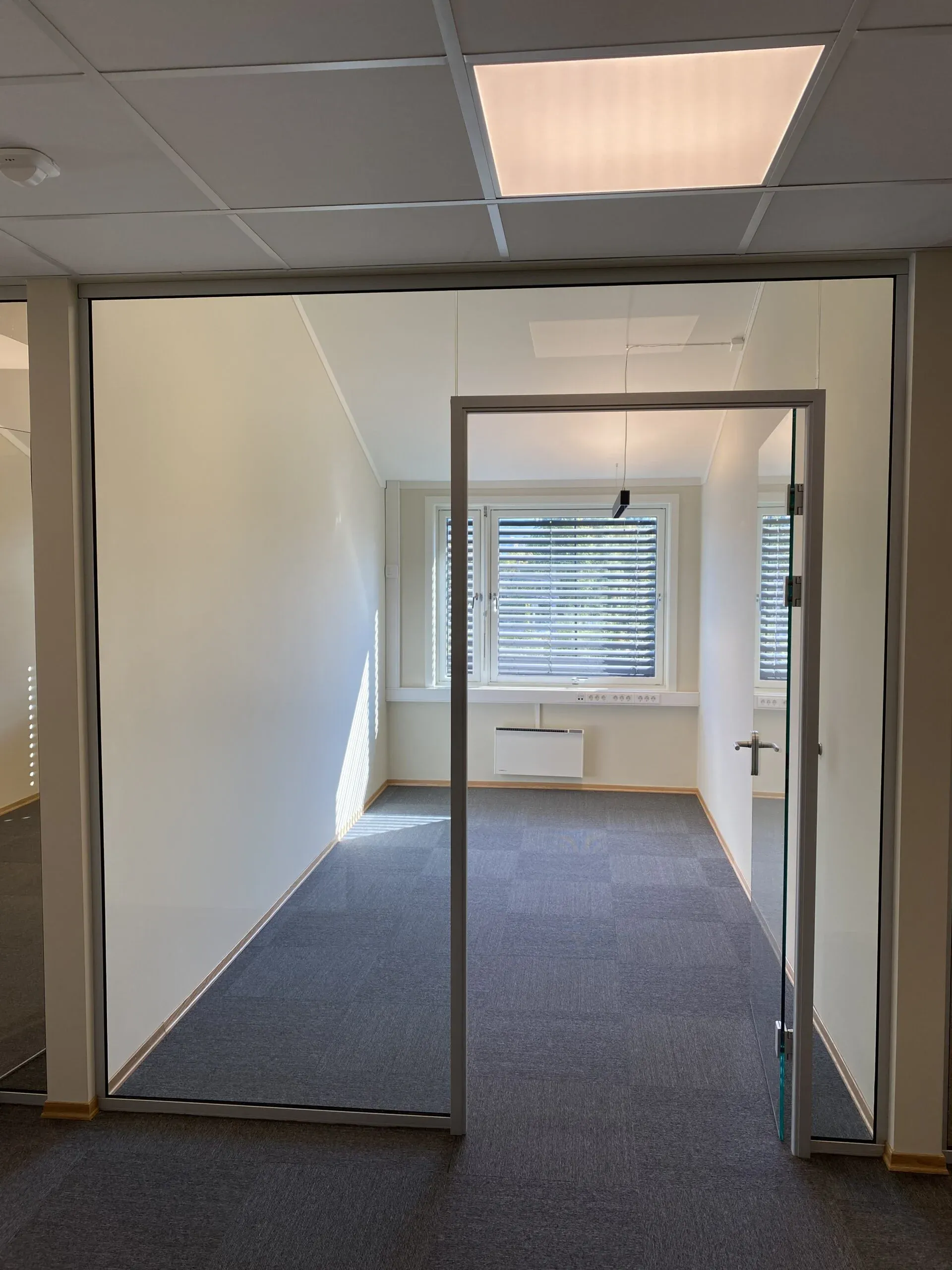 Tomt kontor med glassvegg og dør